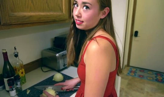 A girl in a red dress in the kitchen is ready for hard home ...